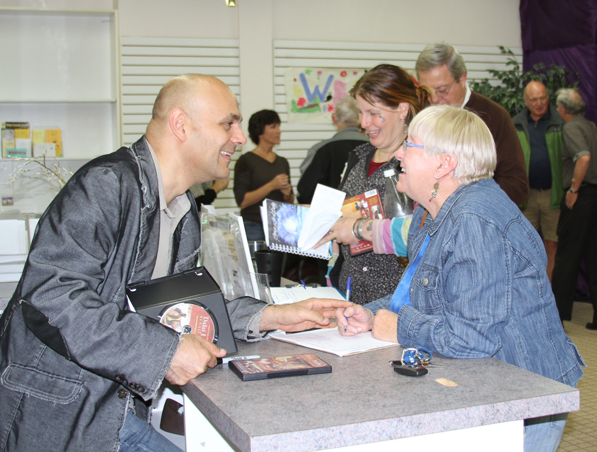 Director Khashyar Darvich signing DVDs and speaking with an audience member after a screening of 'Dalai Lama Awakening'